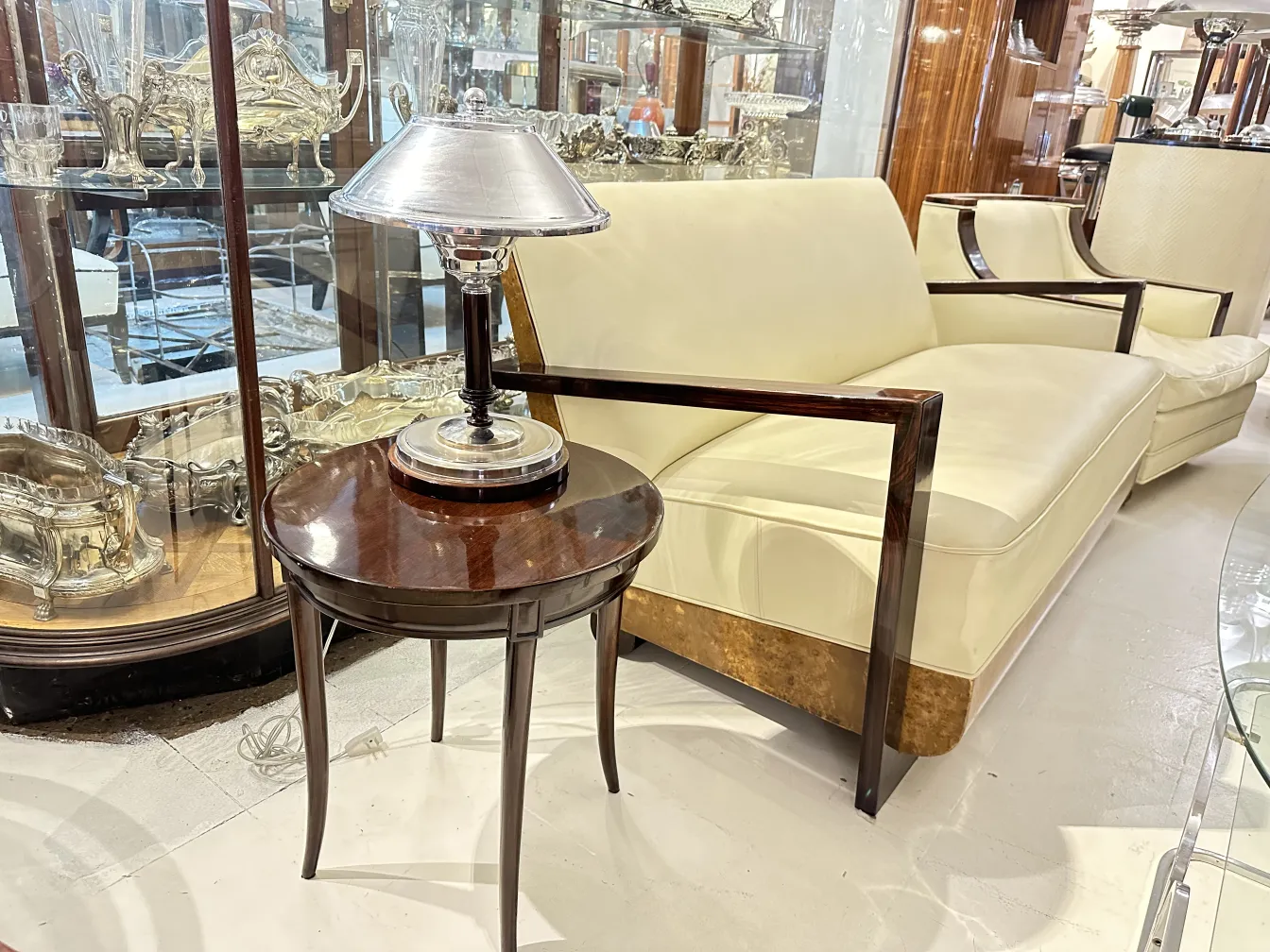 Antiker runder Tisch mit Lampe oben, moderner Sofa im Hintergrund