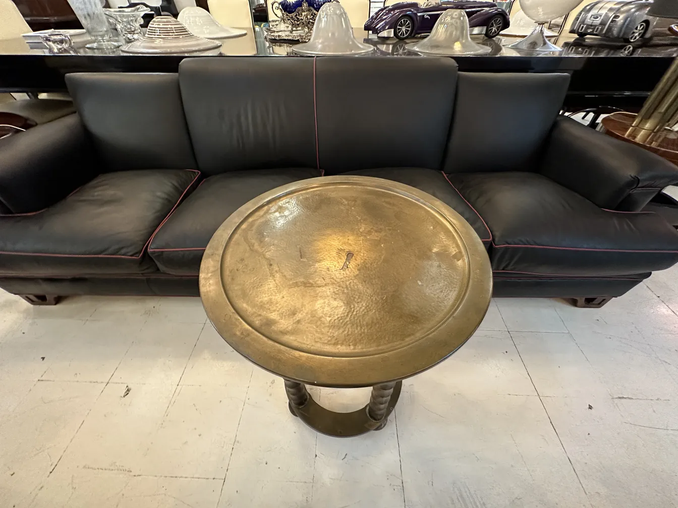 antique small table with shiny surface, near a black sofa