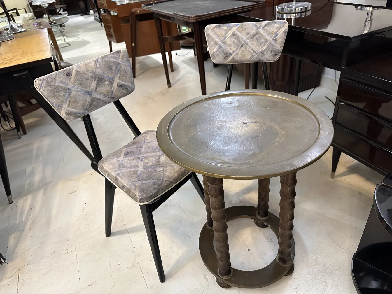 mesita antigua con patas decorativas y superficie redonda