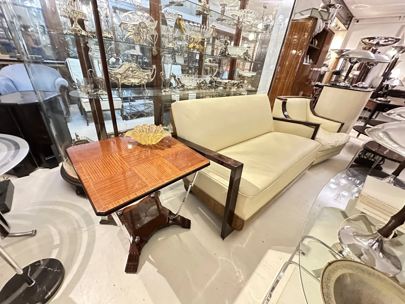 mesita antigua de madera con decoración sutil, junto a un sofá