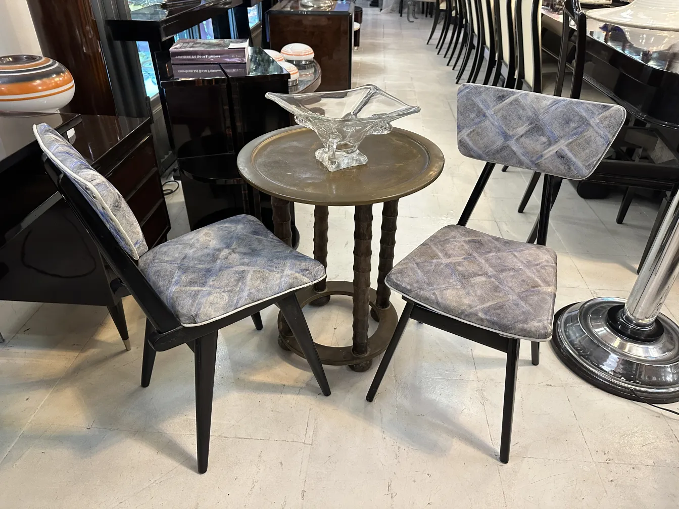 Antiker kleiner Tisch mit Stühlen in einer eleganten Umgebung.