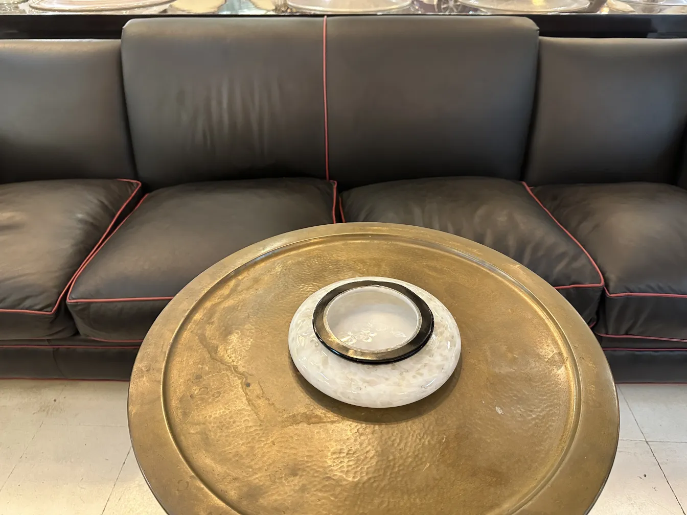 mesita antigua con detalles decorativos junto a un sofá negro