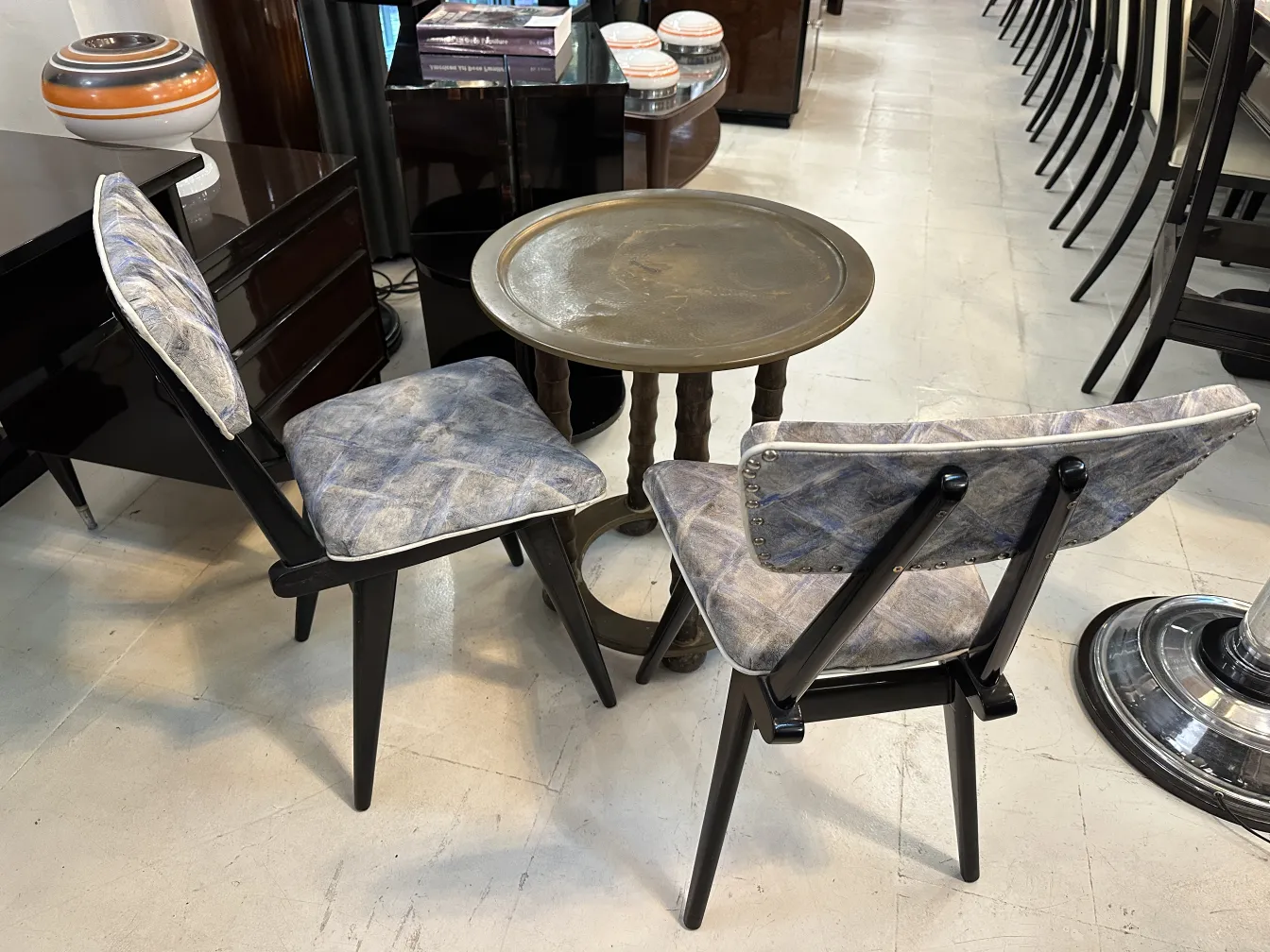 tavolino antico dal design classico con sedie sullo sfondo