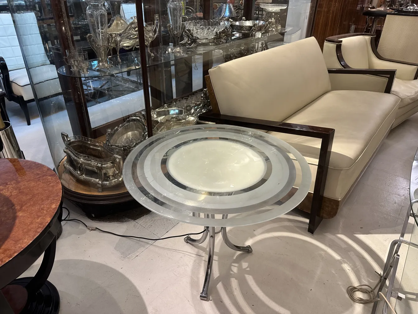 Mesita antigua de salón con diseño elegante y pie distintivo en ambiente clásico.