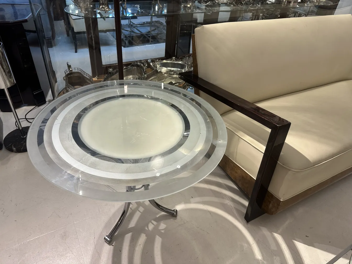 antique round small table with decorative patterns, next to a sofa