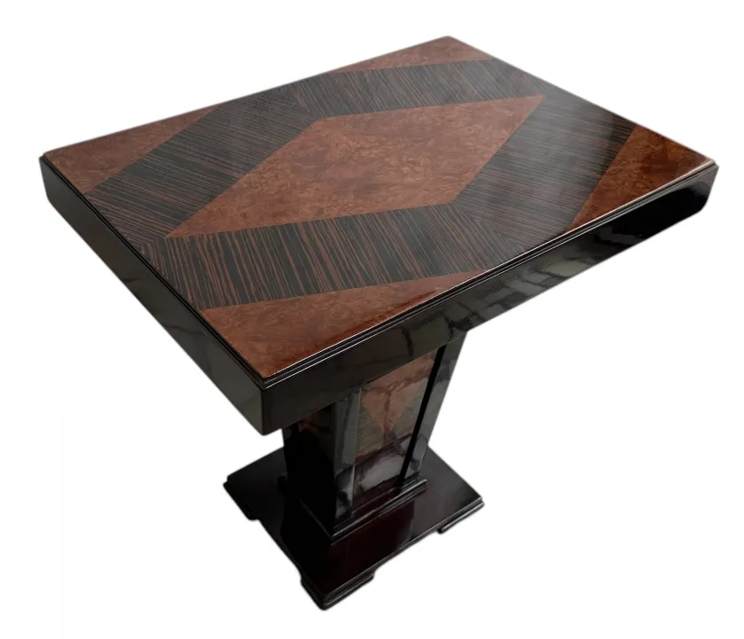 Petite table antique avec un design géométrique en haut, ajoutant du charme à un cadre élégant.