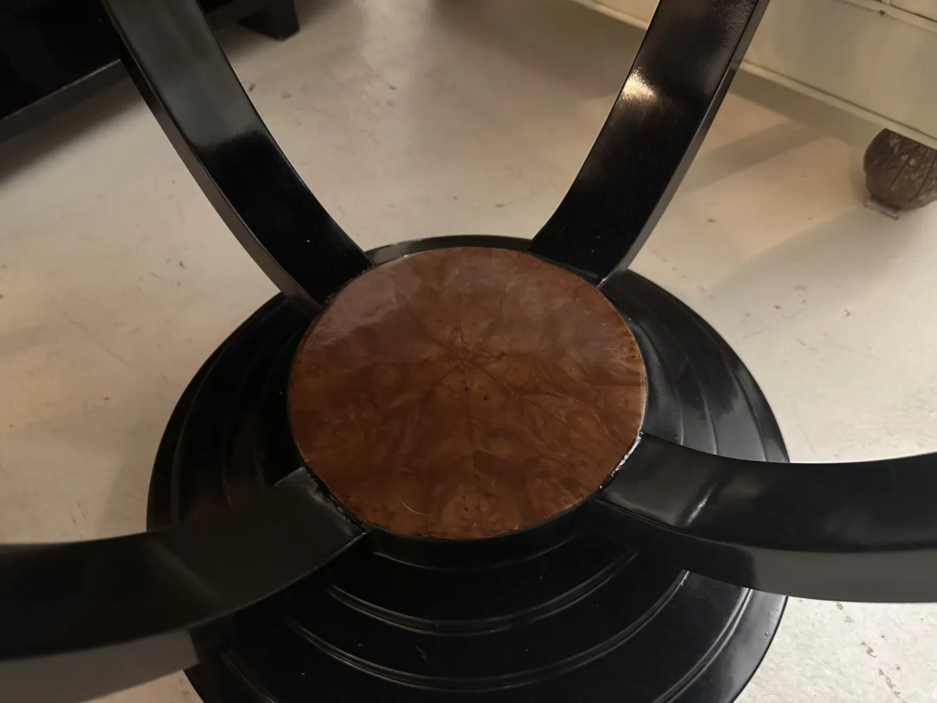 小さな古いテーブルは中央の詳細と黒い足を持っています