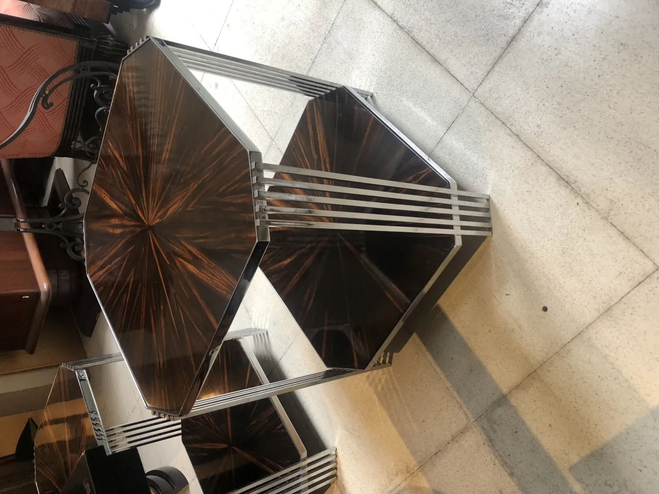 Duas mesinhas antigas com formas geométricas e design elegante, embelezando um ambiente clássico.