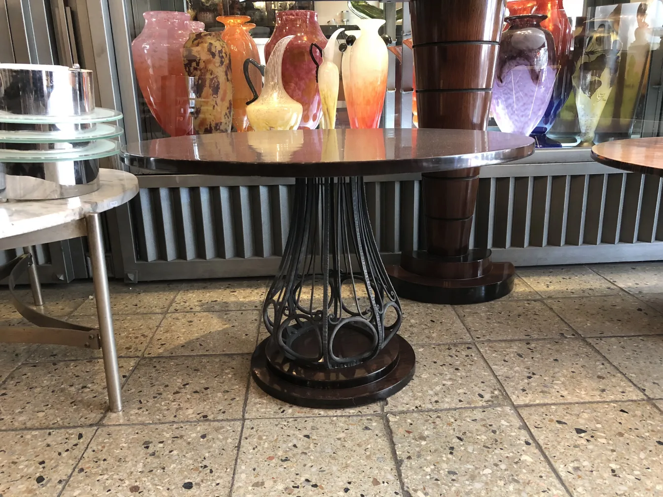 Two antique small tables with decorative elements, surrounded by objects