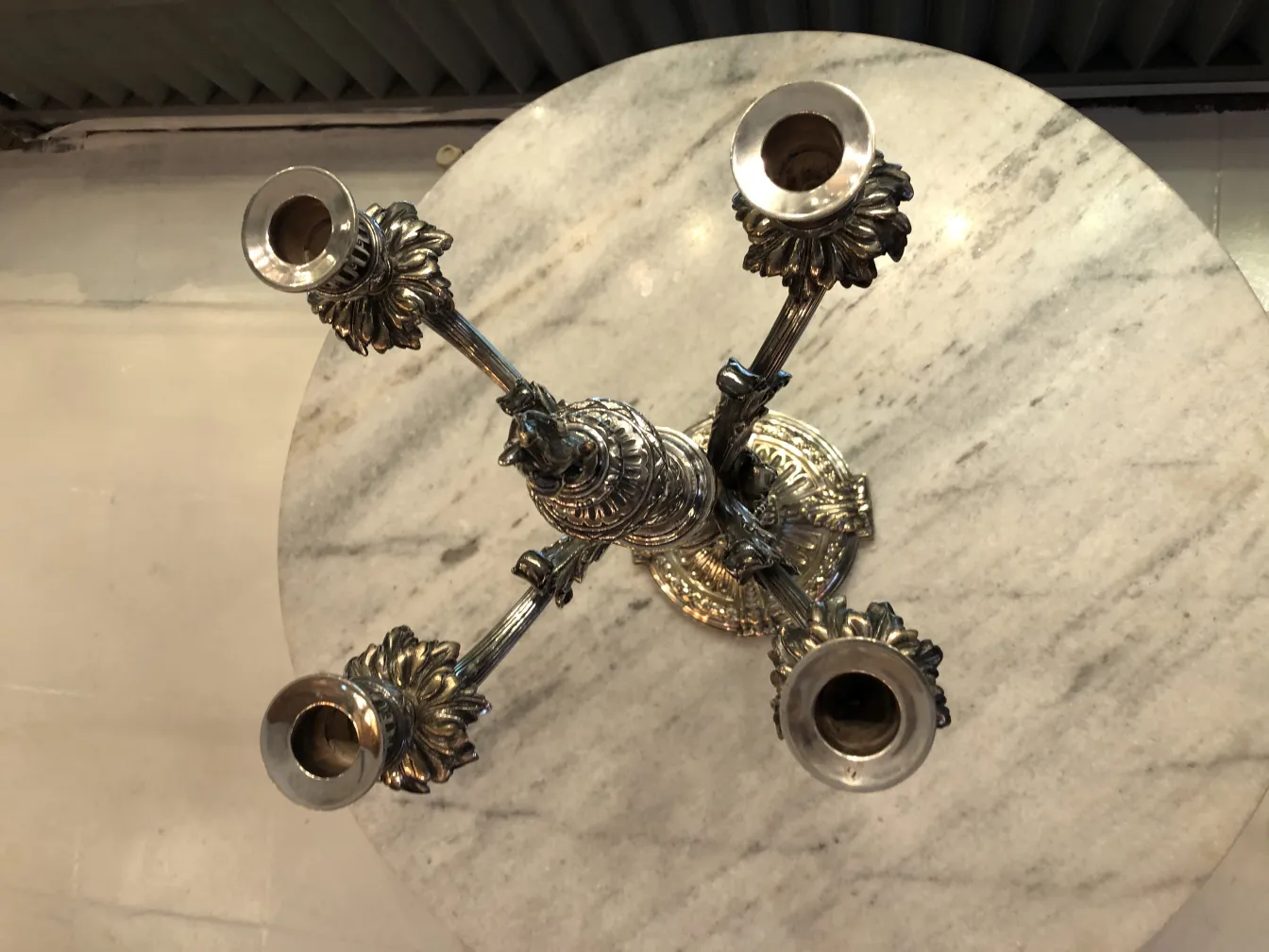 due candelabri antichi con dettagli decorativi su un tavolo di marmo