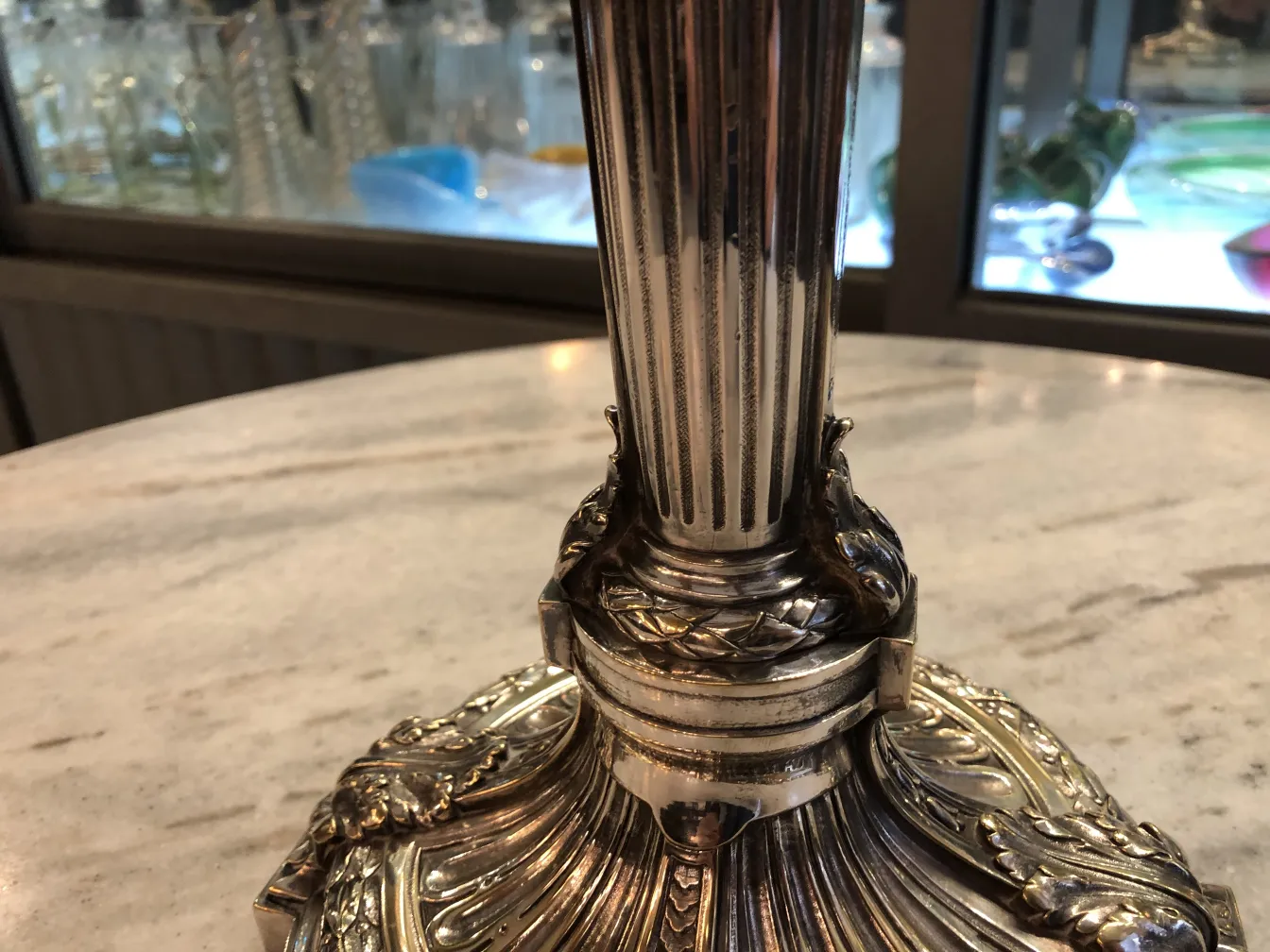 Two antique candlesticks with intricate design in an elegant setting.