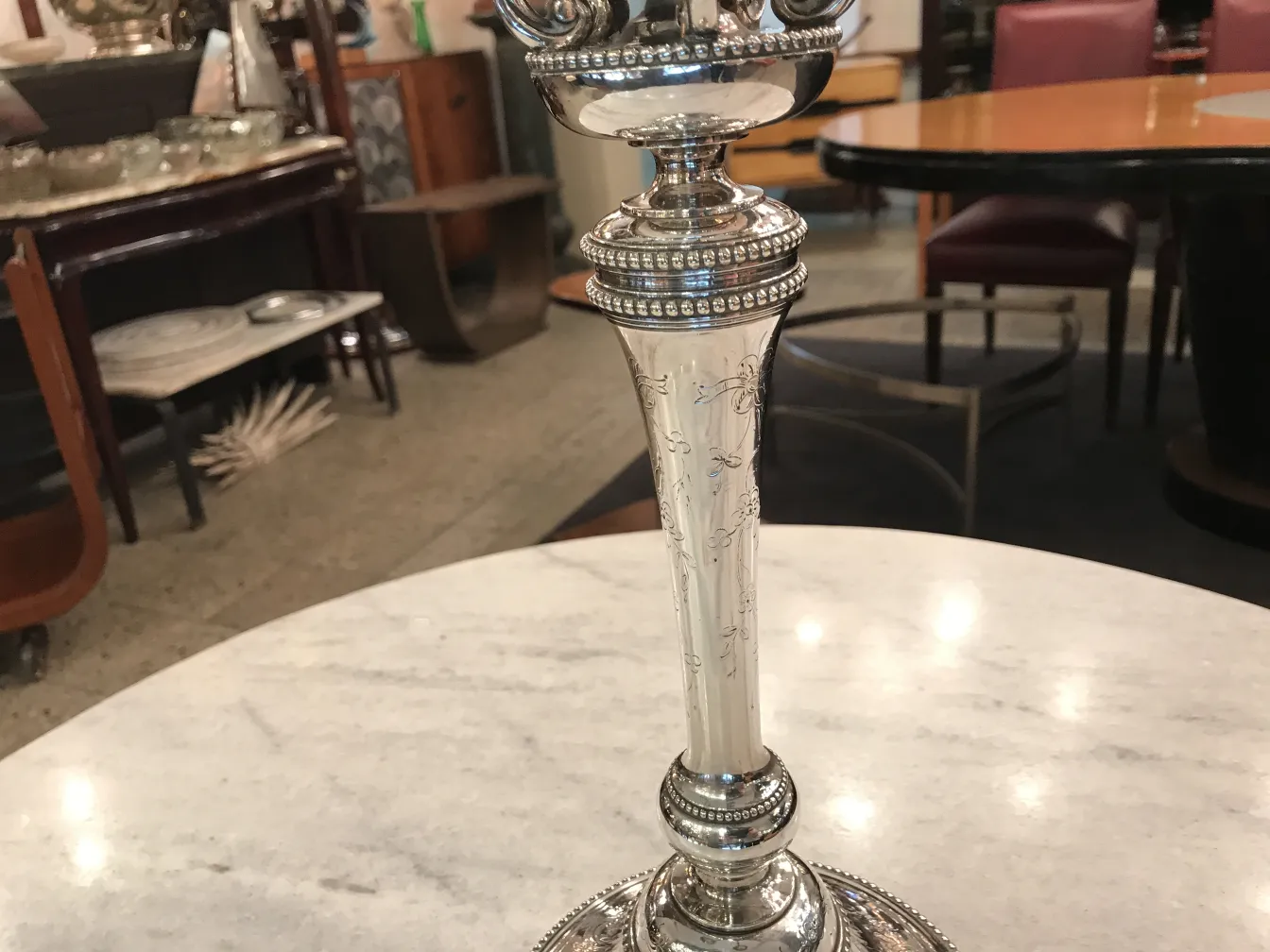 Set of 2 antique art nouveau candlesticks on a marble table.