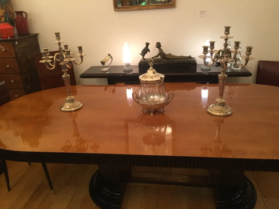 dos candelabros antiguos decorando una mesa de madera, con un ambiente acogedor y elegante.