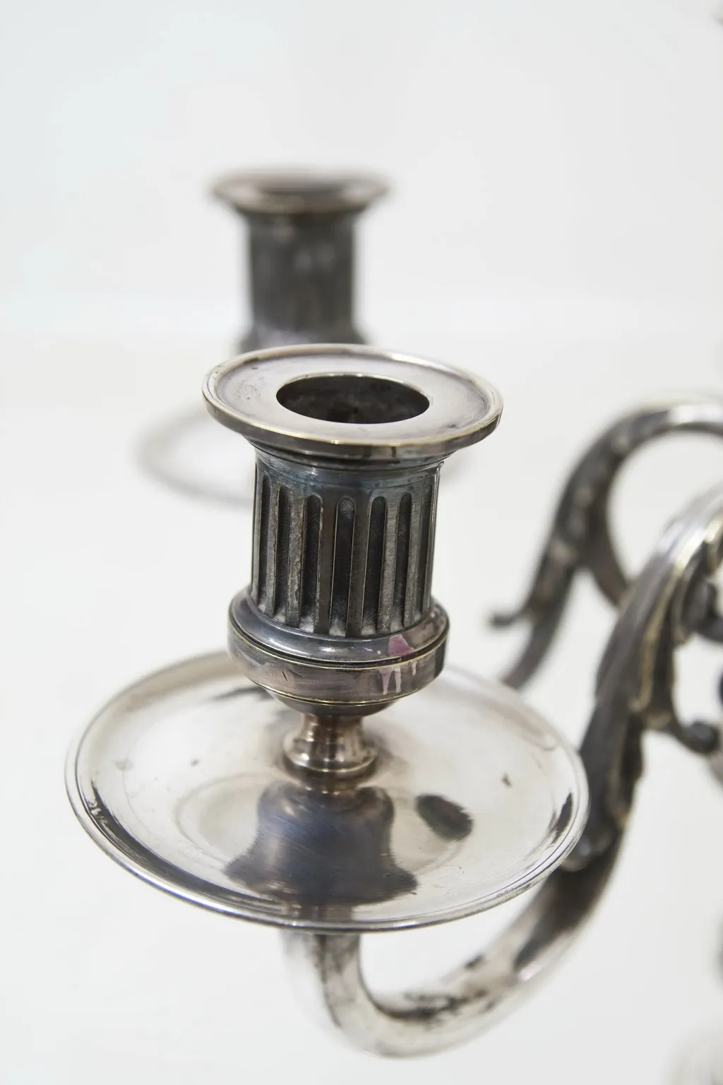 Deux candélabres anciens avec un design classique dans un cadre élégant.