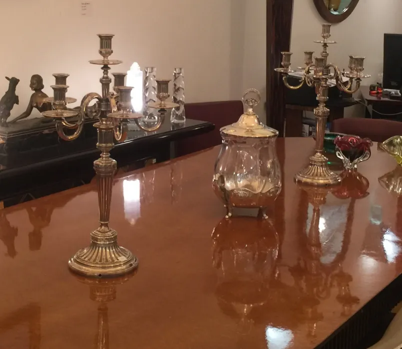 two antique decorative candelabra on wooden table