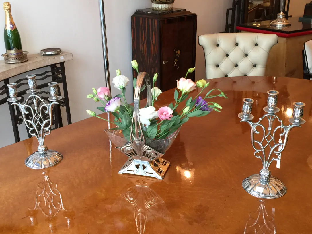 dois castiçais antigos em estilo Art Nouveau em uma mesa