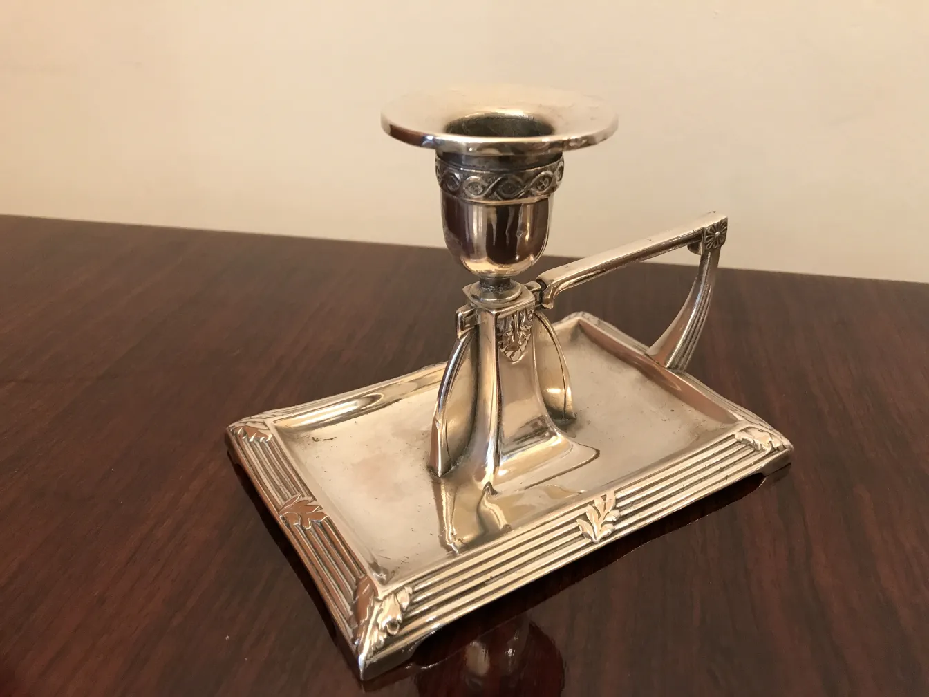 two antique candle holders on a decorative base