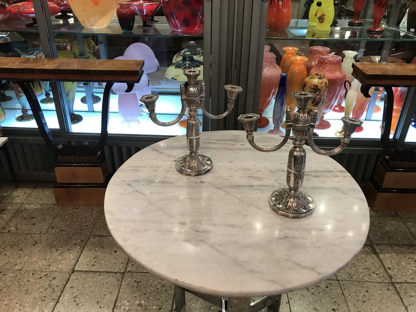 2 antique candelabras on a marble table, decorative background