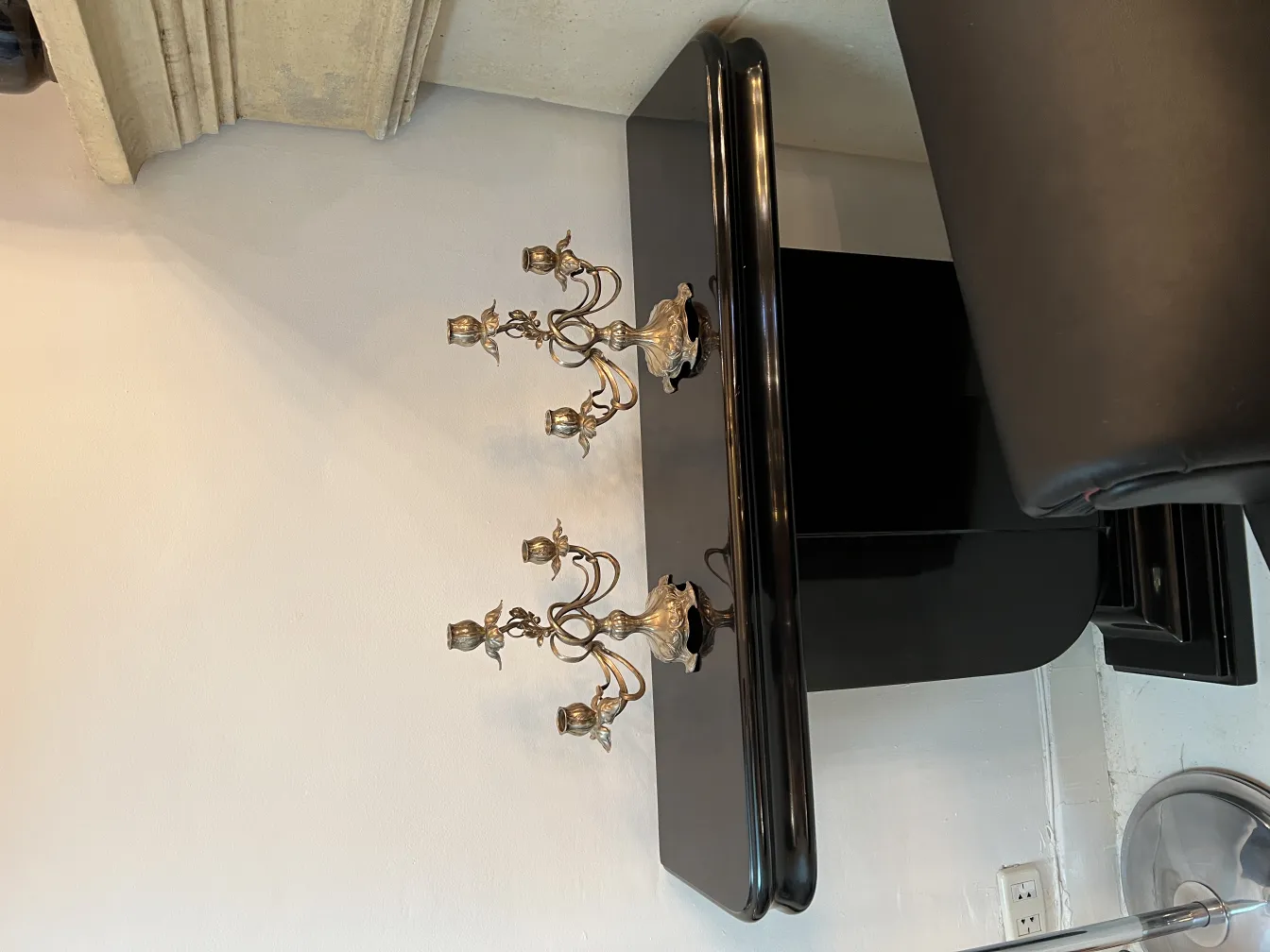 Dos candelabros antiguos de estilo art nouveau sobre mesa negra