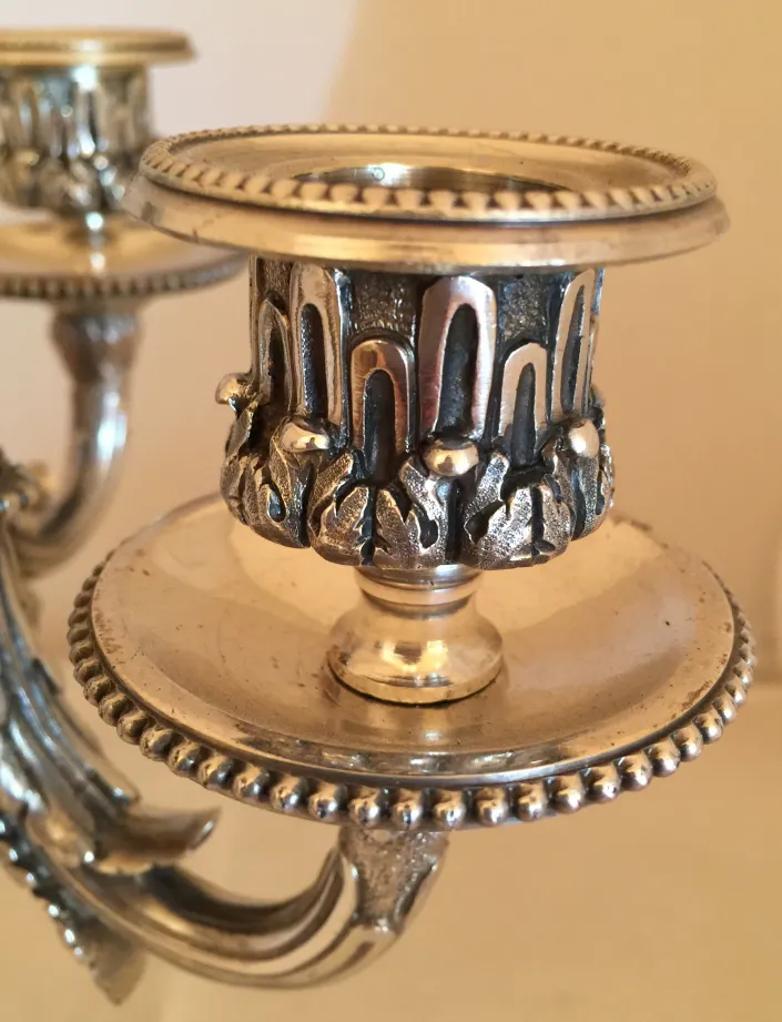 Детальный вид двух старинных подсвечников с дизайном art nouveau.