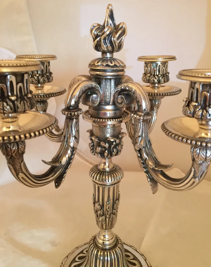 due candelabri antichi con dettagli decorativi a forma di foglie