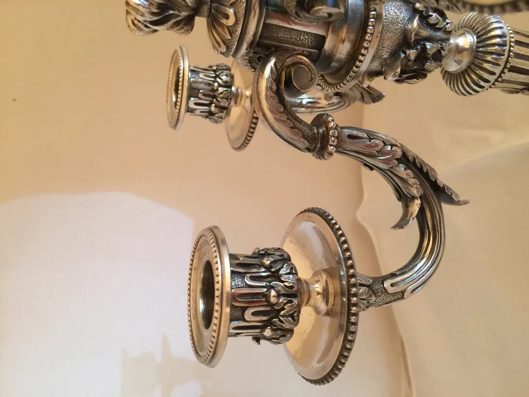 two antique candelabras with beautiful ornamental details on a soft background