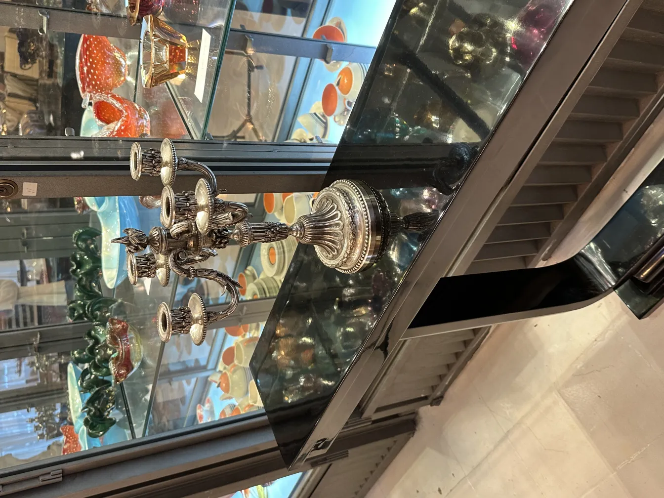 2 antike Kerzenhalter mit einzigartigen Details neben anderen Dekorationsobjekten