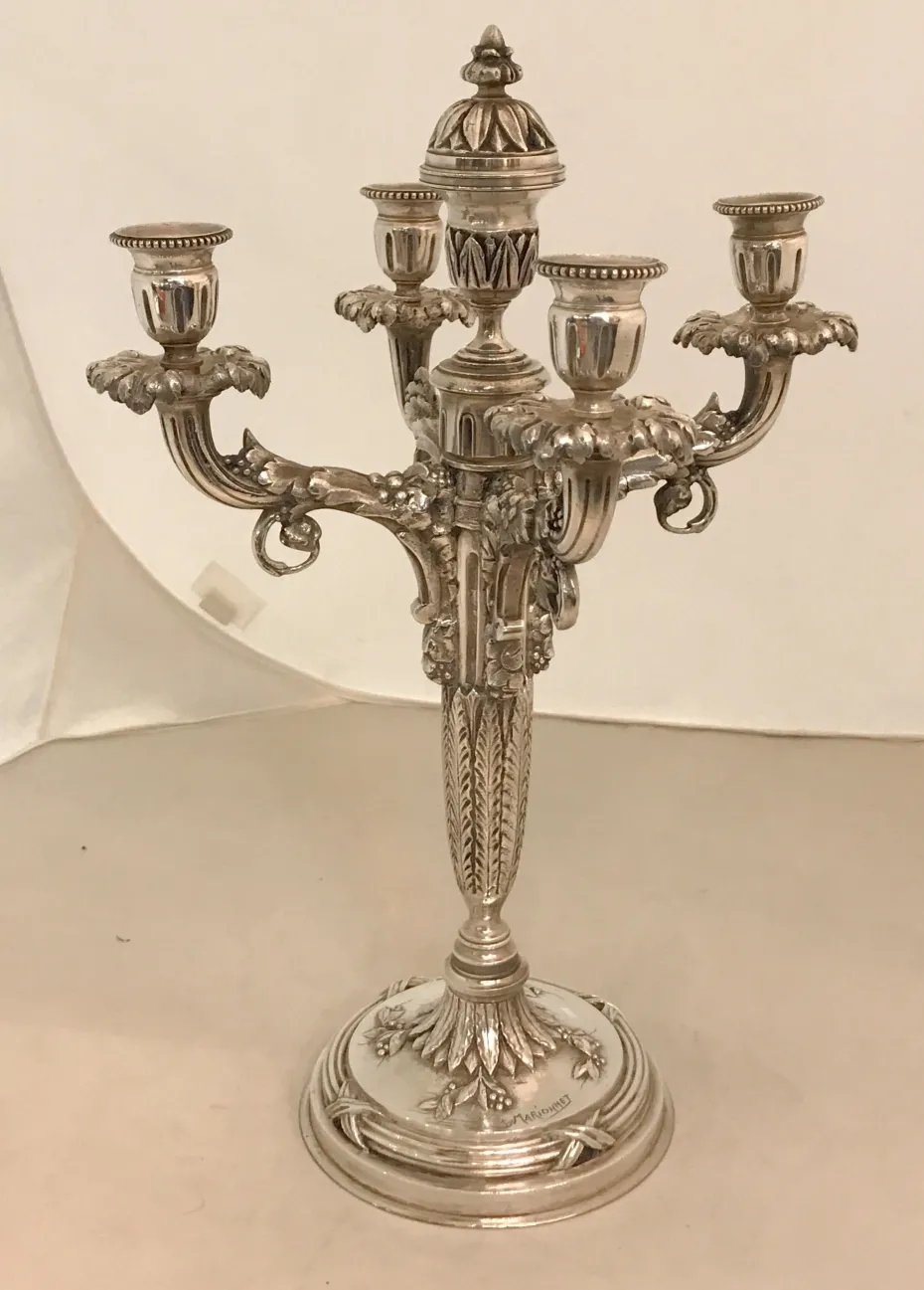 two antique candelabras with elaborate shiny details
