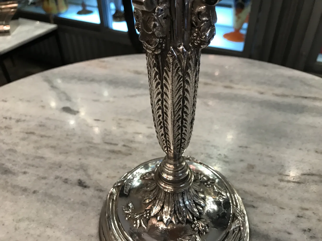 Two antique candelabras with decorative details on a table