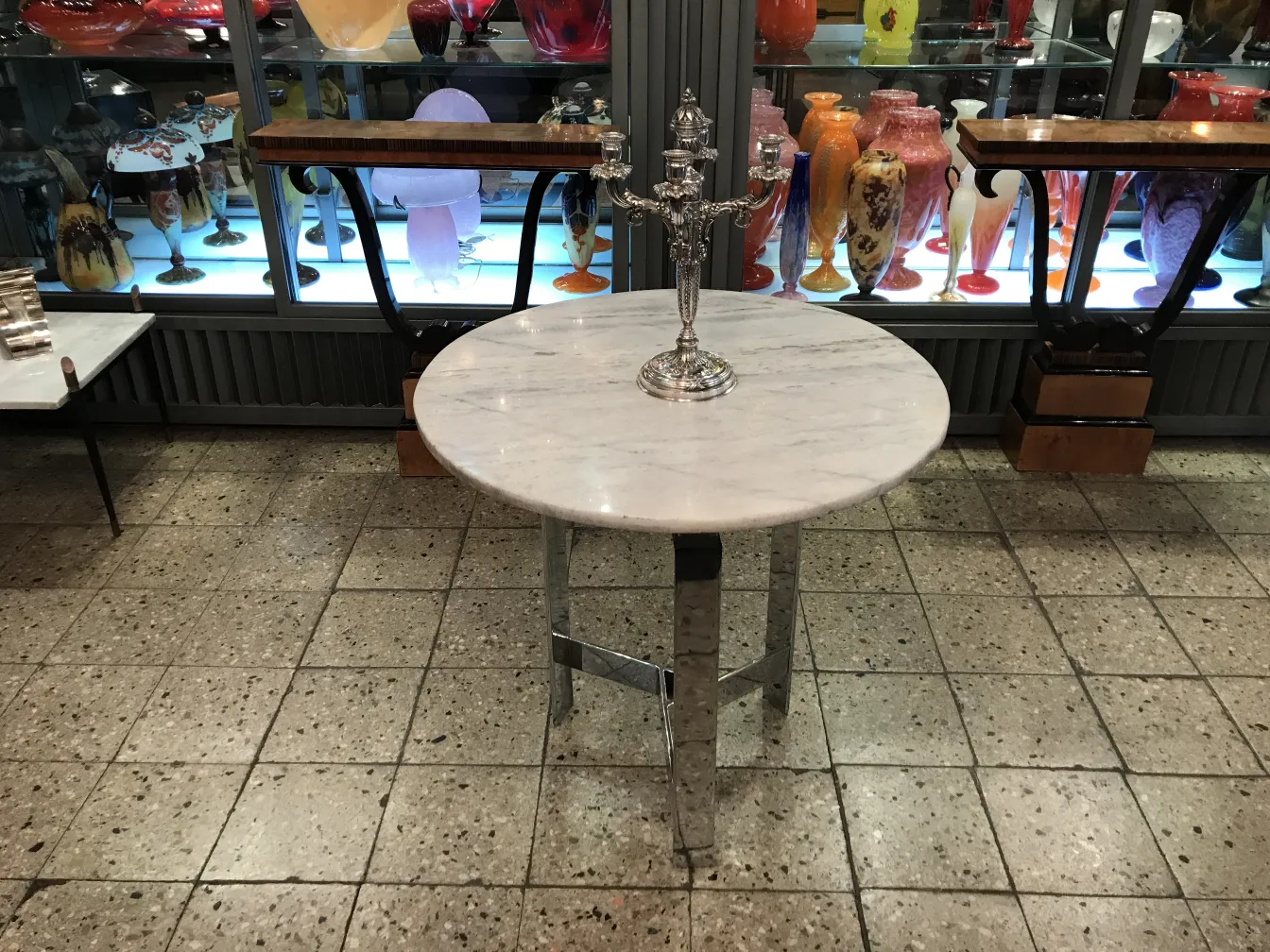 两只古董蜡烛台放在桌子上，背景五彩斑斓