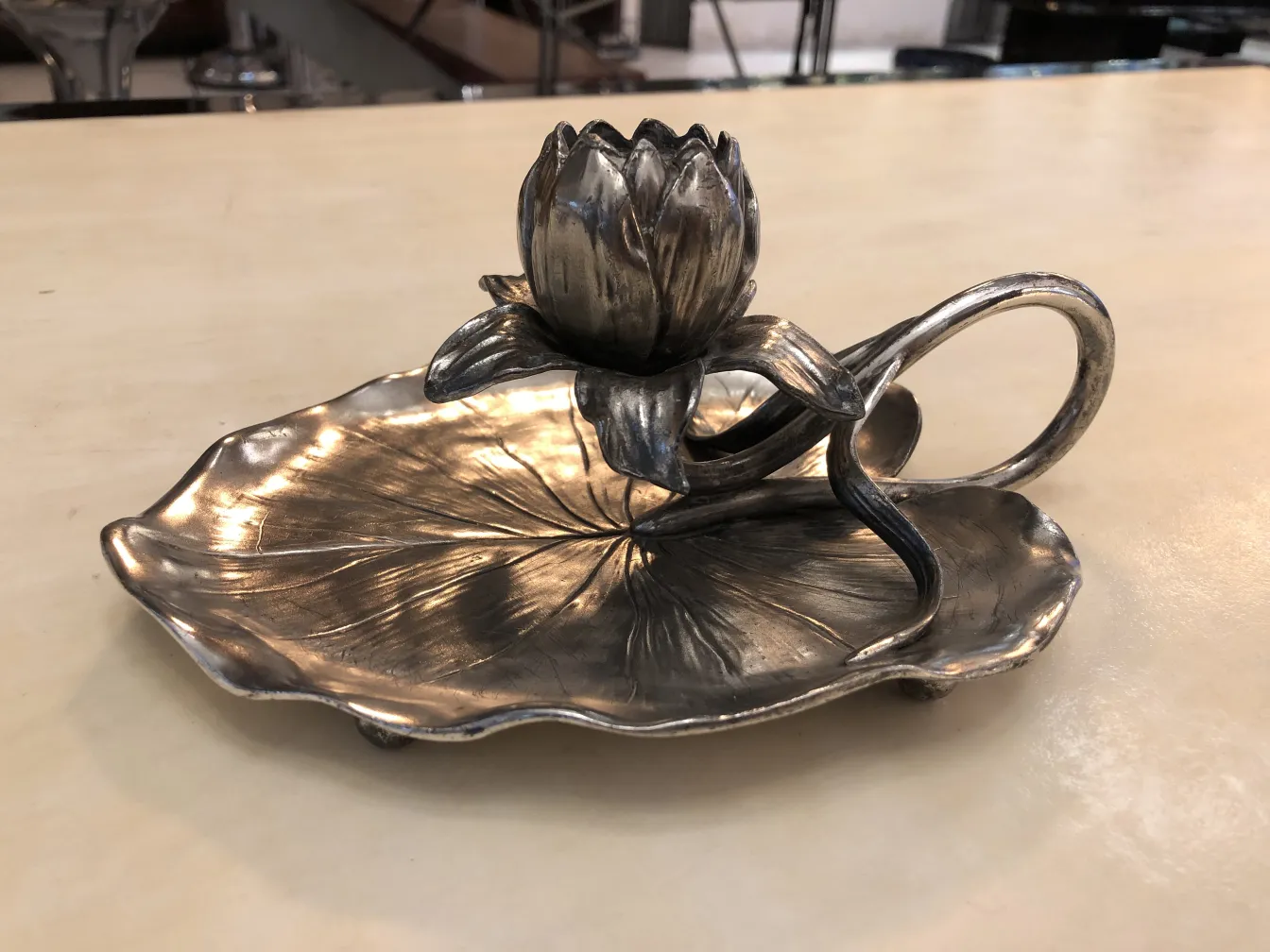 Antique candelabra with floral design on a leaf-shaped base.