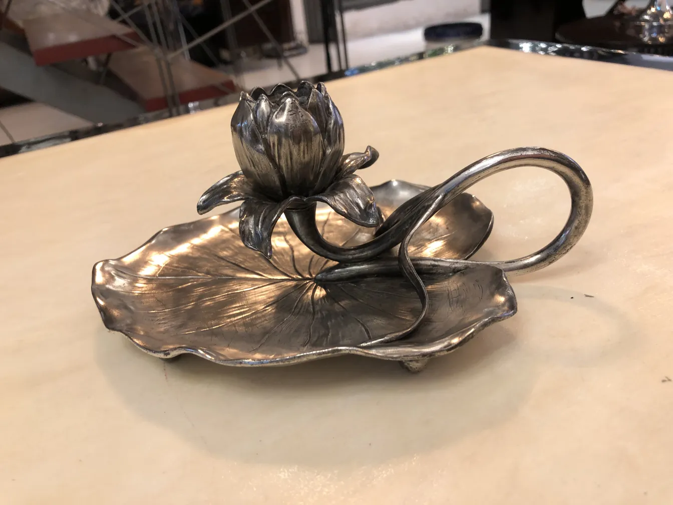 Candelabro antico con design floreale alla base, elegante e artistico.