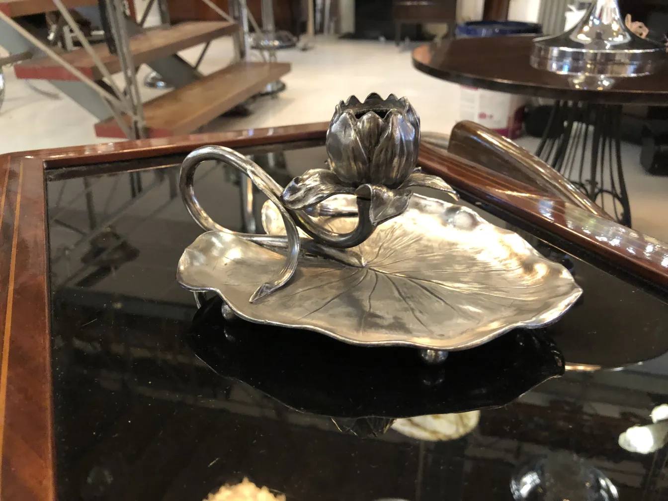 antique candelabra featuring a lotus flower design and decorative base in an antique setting