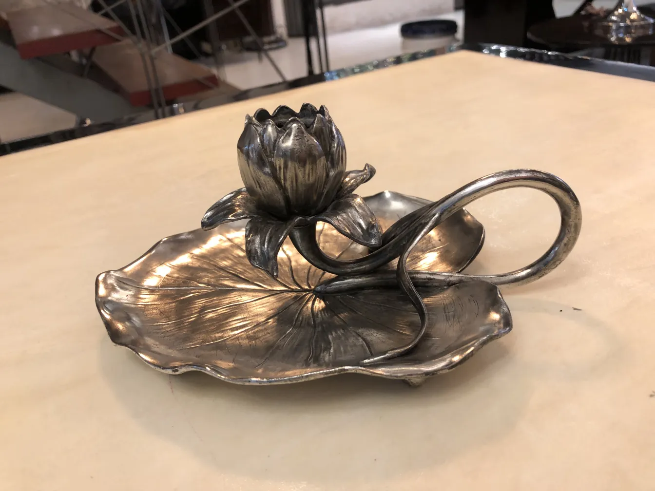 candelabre ancien avec une fleur en haut et une base décorative