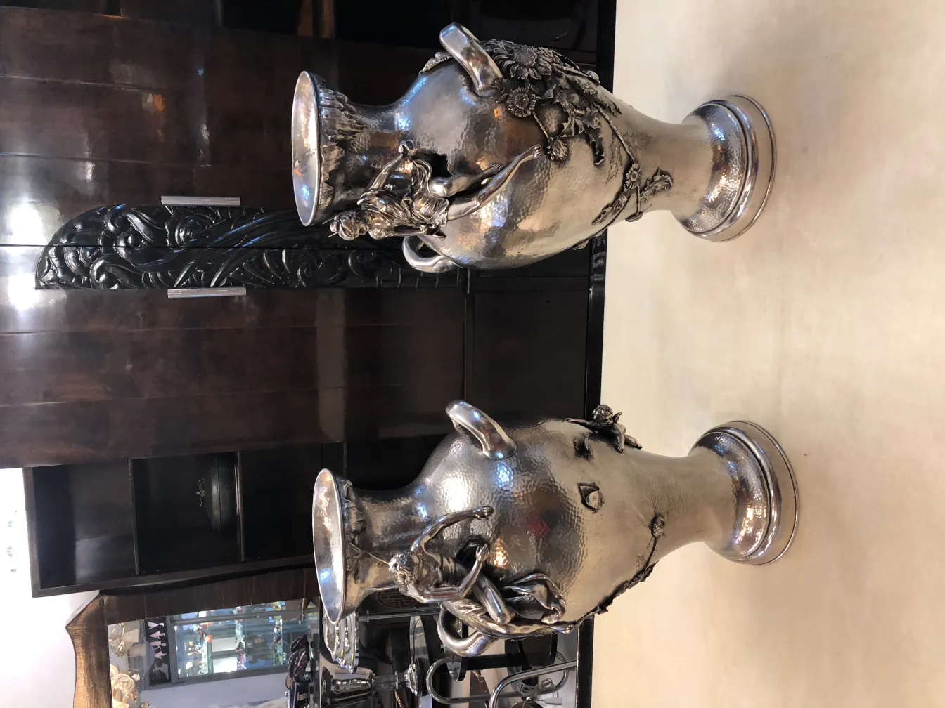 Dos floreros antiquos en una mesa, con detalles decorativos