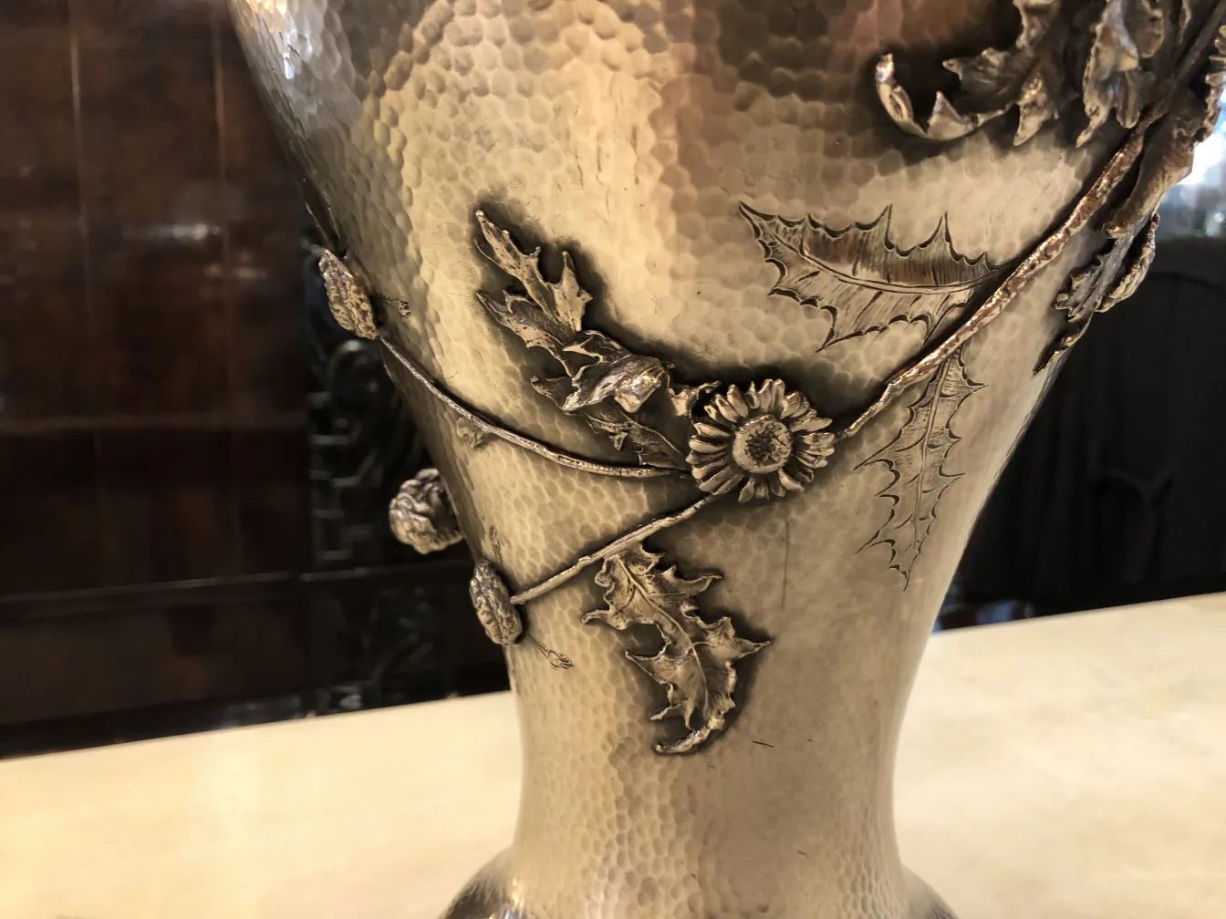 Vasos antigos adornados com folhas, estilo Art Nouveau, em um ambiente elegante.