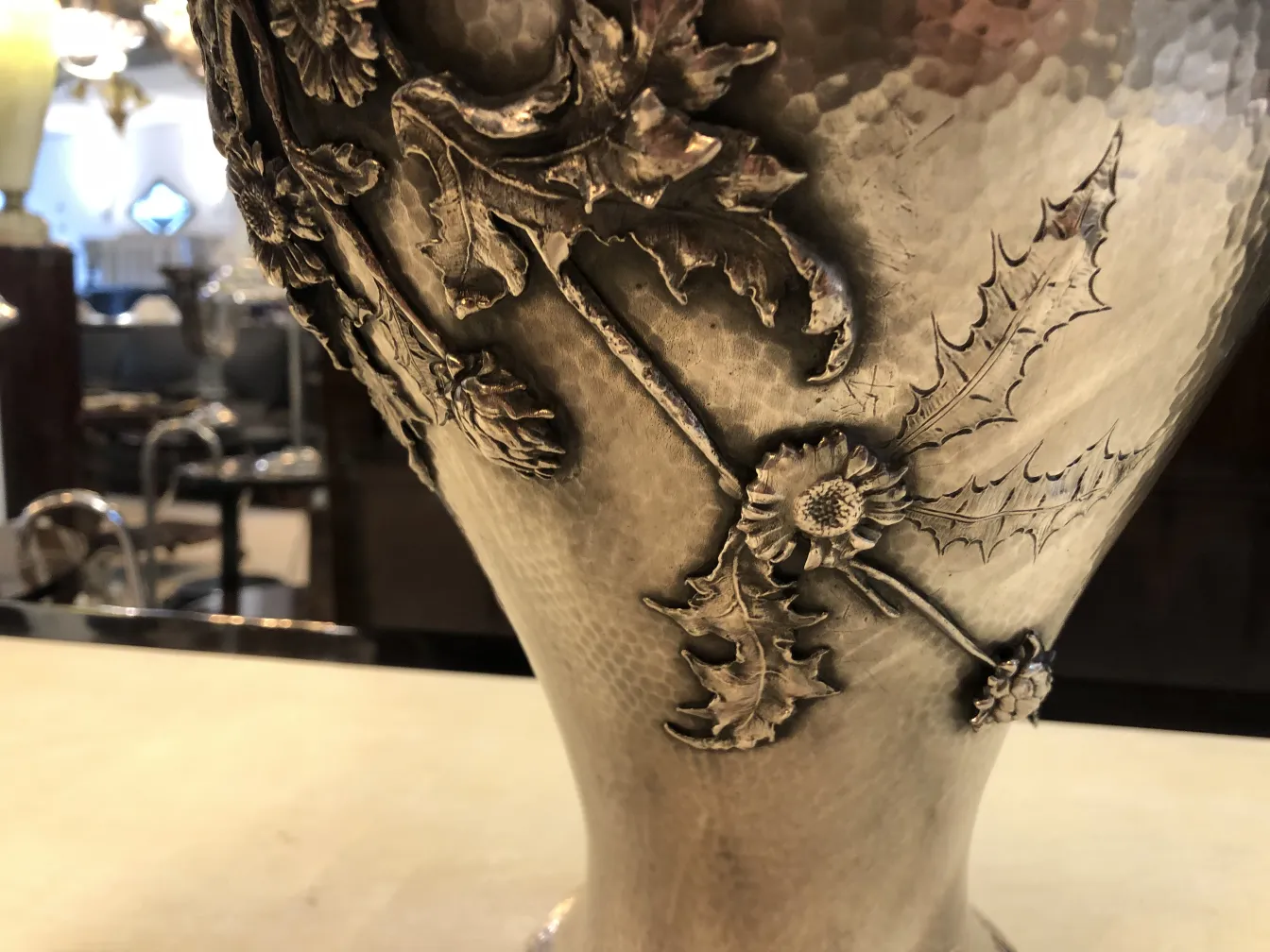 Dois vasos antigos com decorações florais em relevo Art Nouveau, exibidos em um ambiente elegante.