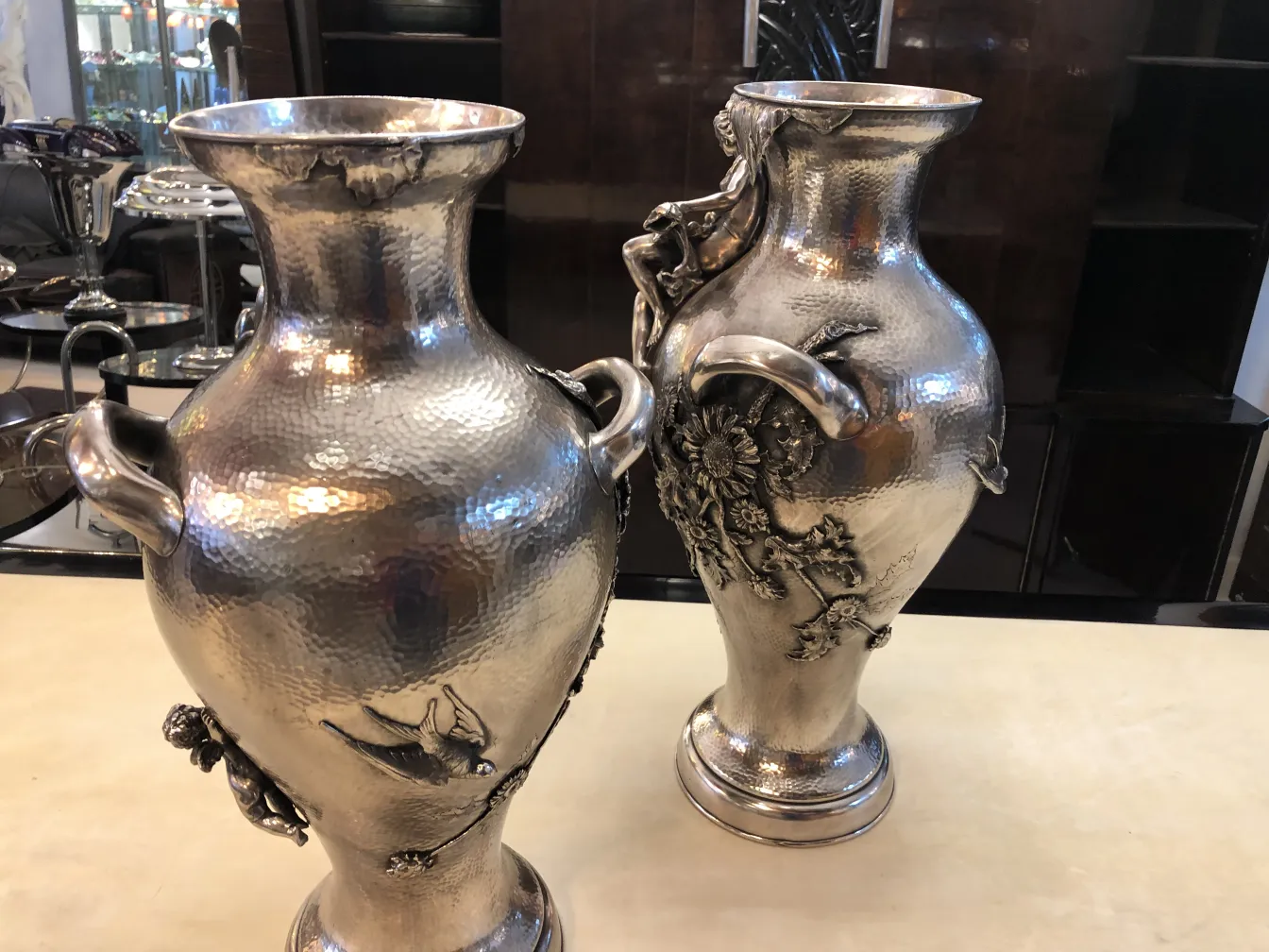 due vasi antichi con design Art Nouveau in un ambiente elegante con dettagli ornamentali.