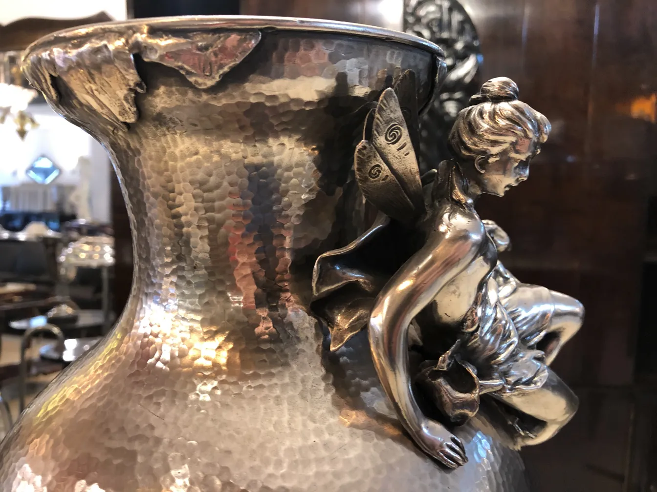 Visão lateral de dois vasos antigos decorados ao estilo Art Nouveau, com figuras em relevo.