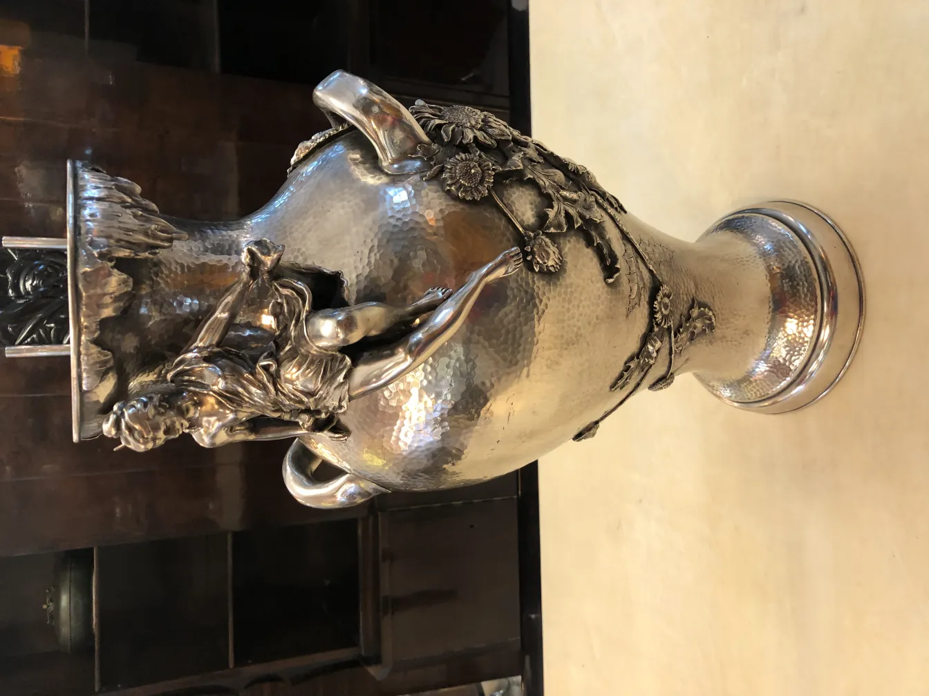 Vaso antico art nouveau con dettagli decorativi in rilievo, sfondo scuro.