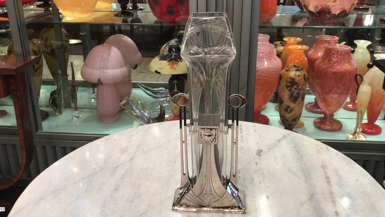 2 个古董花瓶 art nouveau 带优雅设计，背景中有其他装饰物品。