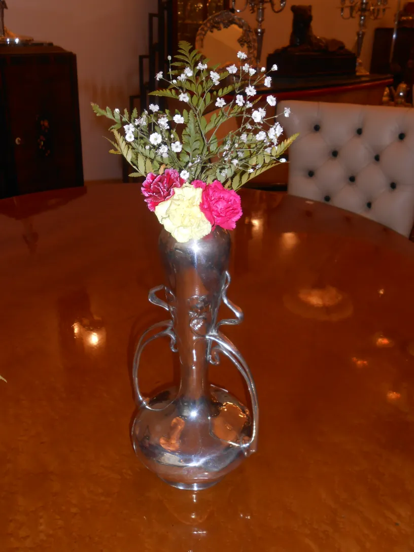 Antiguos floreros decorados con flores en un ambiente clásico.