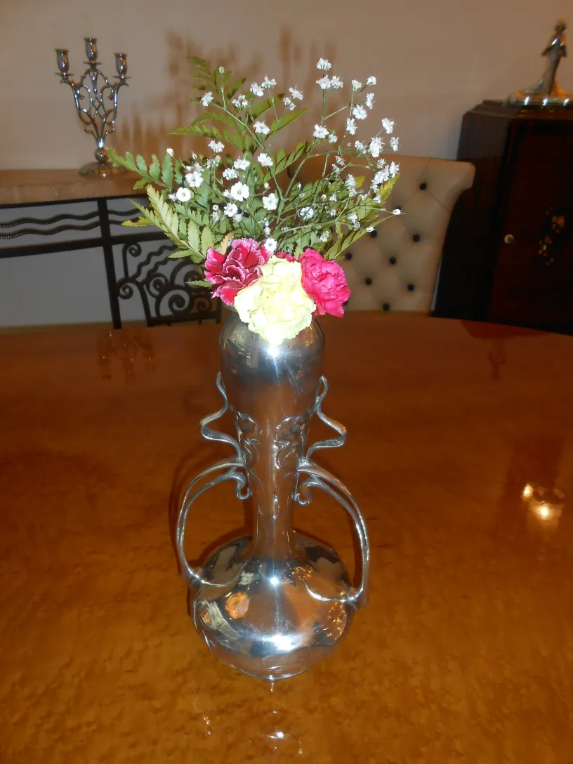 Vasos antigos de art nouveau com flores decorativas em um ambiente aconchegante.