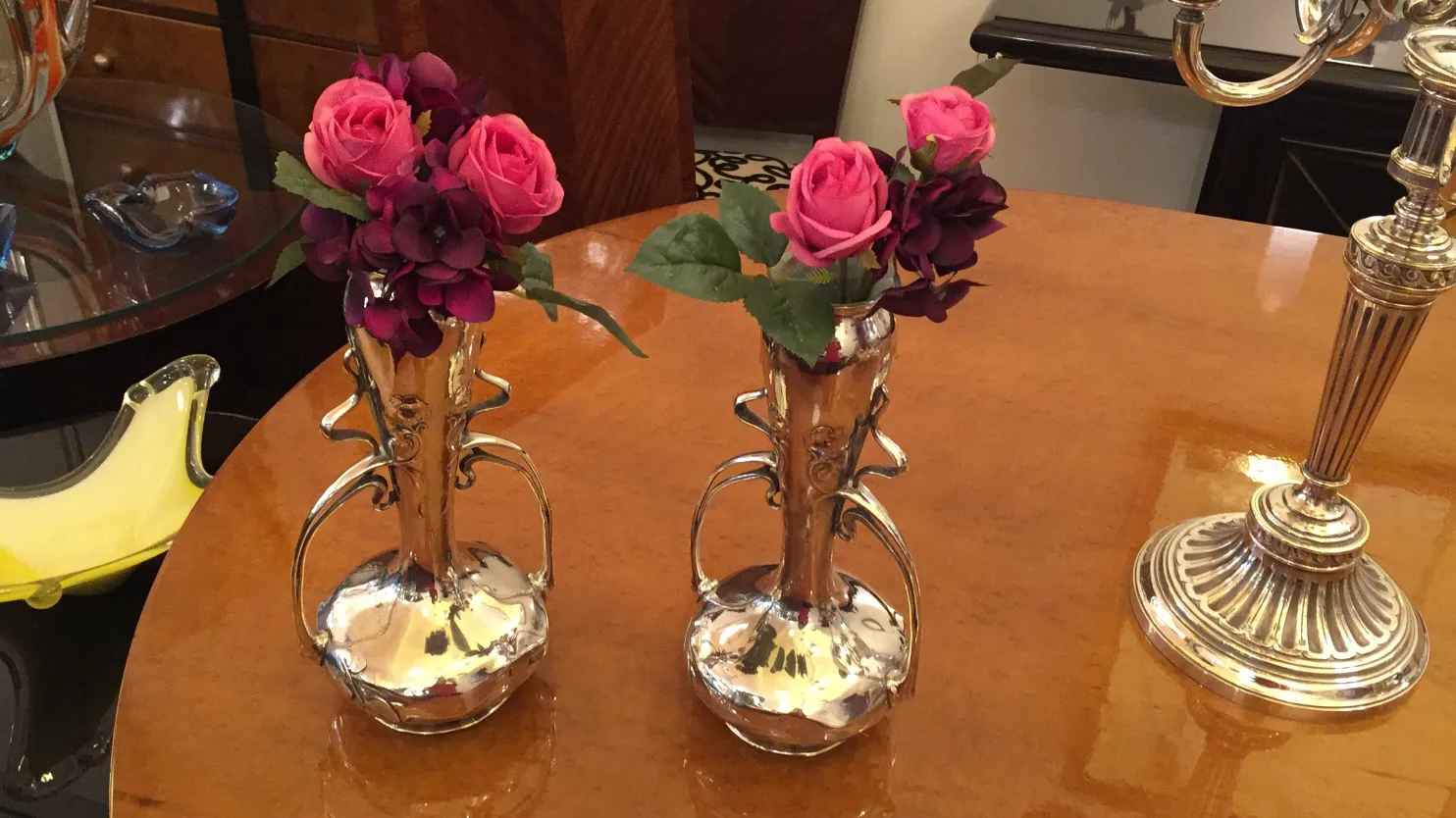 deux vases anciens avec des fleurs roses sur la table