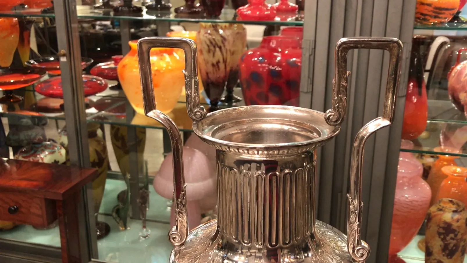 Vases décoratifs anciens avec des détails gravés et des poignées, entourés de pièces en céramique colorées.