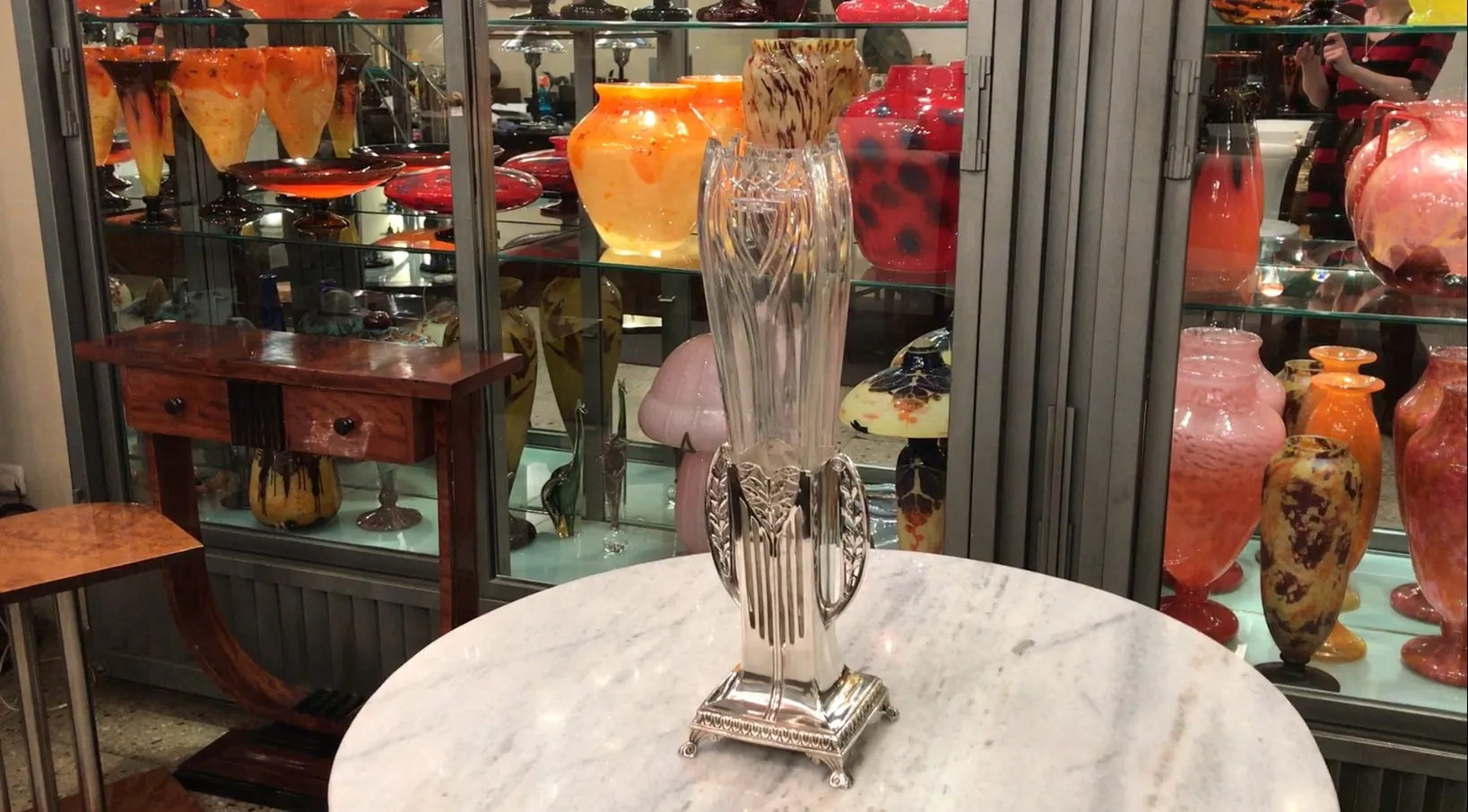 两个古董花瓶展示在玻璃柜中，背景色彩鲜艳。