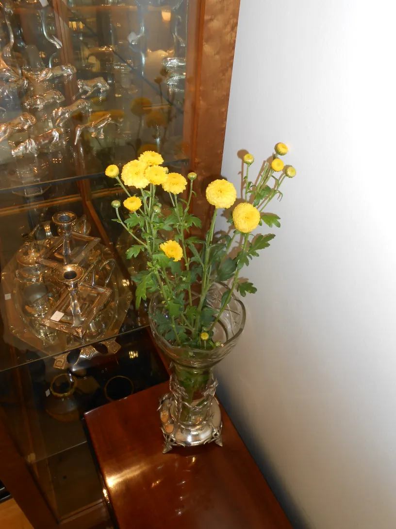 dos floreros antiguos con flores amarillas en un ambiente elegante