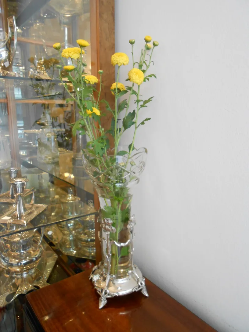 dos floreros antiguos con flores amarillas en un ambiente elegante