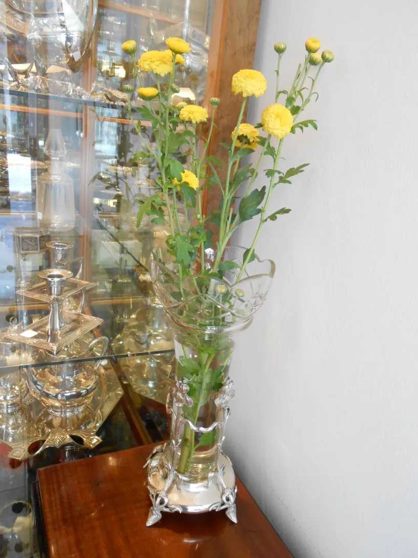 Dois vasos antigos com flores amarelas decorativas.