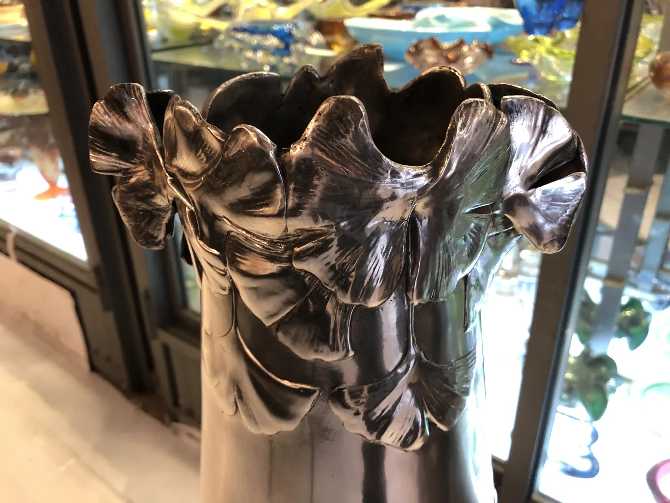 antique vase with wavy edges and carved leaves, blurred background